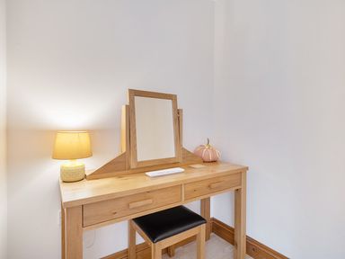 A vanity table with a mirror and lamp at 2 Bed, Sleeps 4 with Parking and EV charging in Wadebridge