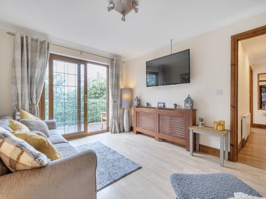 A living room with a television and sliding door at 2 Bed, Sleeps 4 with Parking and EV charging in Wadebridge