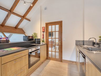A kitchen with stove and microwave at 2 Bed, Sleeps 4 with Parking and EV charging in Wadebridge