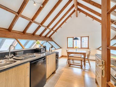 A kitchen with a sink, dishwasher, and table at 2 Bed, Sleeps 4 with Parking and EV charging in Wadebridge