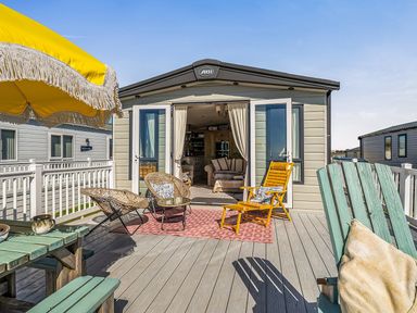 An outdoor area with chairs and an umbrella at 2 Bed Caravan, Sleeps 4 with Sea Views, West Lulworth