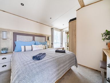 A bedroom with a bed and dresser at 2 Bed Caravan, Sleeps 4 with Sea Views, West Lulworth