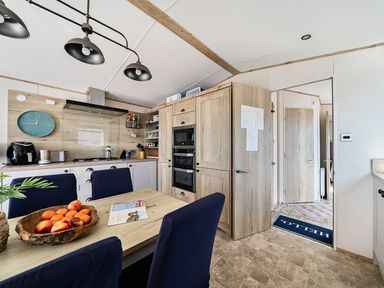 A kitchen with a table and fruit bowl at 2 Bed Caravan, Sleeps 4 with Sea Views, West Lulworth
