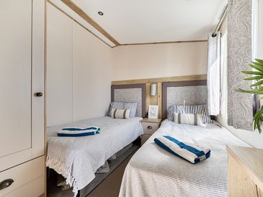A bedroom with twin beds and a nightstand at 2 Bed Caravan, Sleeps 4 with Sea Views West Lulworth