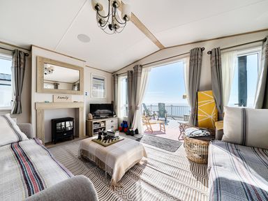 A living room with a fireplace and television at 2 Bed Caravan, Sleeps 4 with Sea Views, West Lulworth