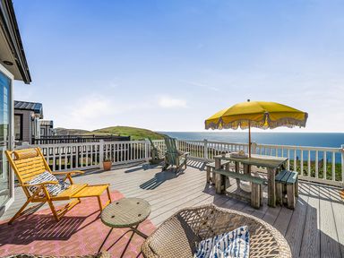 An outdoor deck with seating and a table at 2 Bed Caravan, Sleeps 4 with Sea Views, West Lulworth