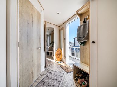 A hallway with a surfboard and shoes organized at 2 Bed Caravan, Sleeps 4 with Sea Views in West Lulworth