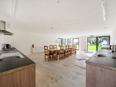 A kitchen with dining table and chairs at Yurt, Sleeps 2 with BBQ and Fire Pit Tregooden Farm near St Tudy