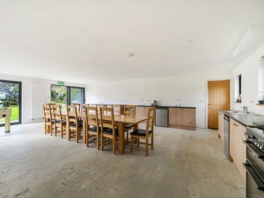 A kitchen with a dining table and chairs at Yurt, Sleeps 2 with BBQ and Fire Pit, Tregooden Farm near St Tudy