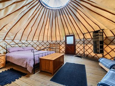 A bedroom with a bed and dresser at Yurt, Sleeps 2 with BBQ and Fire Pit, Tregooden Farm near St Tudy