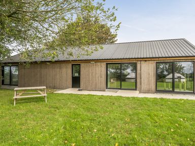 A building with glass doors and a bench at Yurt, Sleeps 2 with BBQ and Fire Pit, Tregooden Farm near St Tudy