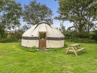 A yurt with a picnic table at Yurt, Sleeps 2 with BBQ and Fire Pit, Tregooden Farm near St Tudy
