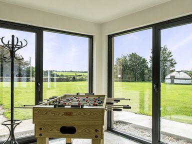 A game room with a foosball table and large windows at Yurt, Sleeps 5 and Dogs Welcome
