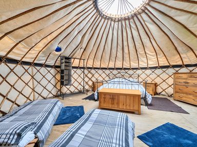A bedroom with wooden furniture in a yurt at Yurt, Sleeps 5 and Dogs Welcome