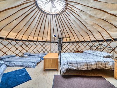 A bedroom with a bed and sleeping mats at Yurt, Sleeps 5 and Dogs Welcome