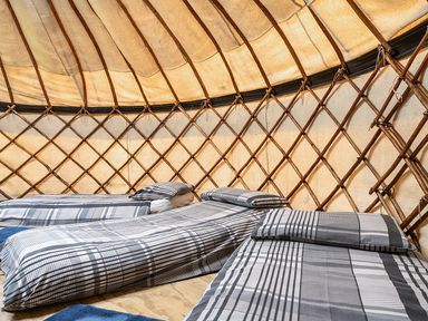 A bedroom with bedding in a yurt at Yurt, Sleeps 5 and Dogs Welcome
