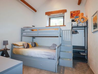 A bedroom with a bunk bed and wardrobe at The Old Dairy 