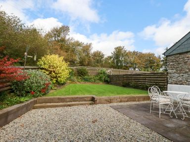 A garden with a table and chairs at The Old Dairy