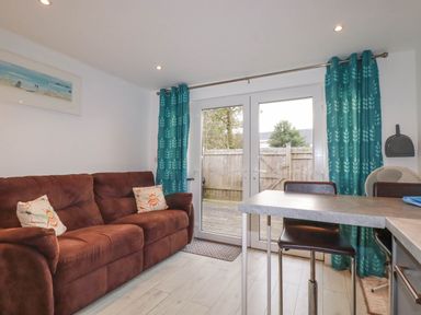 A living room with a sofa and a table at The Old Dairy in Wadebridge