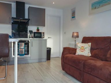 A kitchen with appliances and seating area at The Old Dairy in Wadebridge
