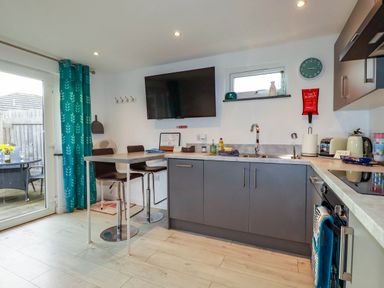 A kitchen with a table and chairs at The Old Dairy in Wadebridge