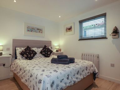 A bedroom with a bed and bedside tables at The Old Dairy in Wadebridge