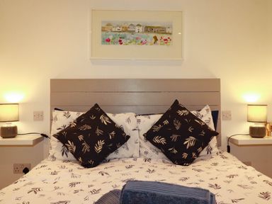 A bedroom with a bed and two lamps at The Old Dairy in Wadebridge