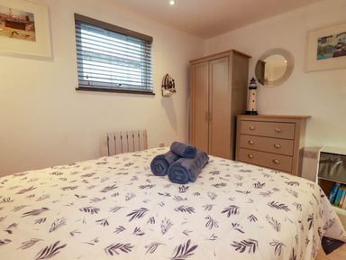 A bedroom with a bed and dresser at The Old Dairy in Wadebridge