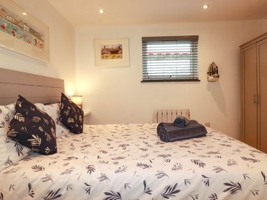 A bedroom with a bed and wardrobe at The Old Dairy in Wadebridge