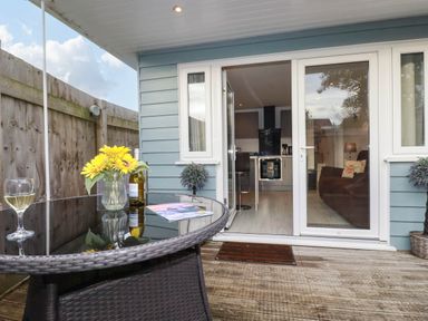 An outdoor seating area with a table and flowers at The Old Dairy in Wadebridge