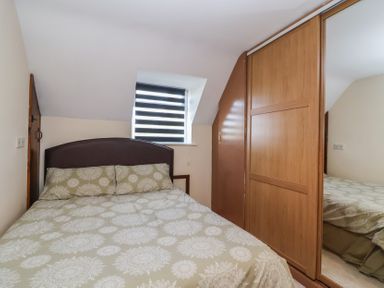 A bedroom with a bed and wardrobe at 19 Hailey Road