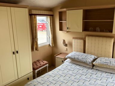 A bedroom with a bed and storage furniture at Haven Perransands, Perranporth