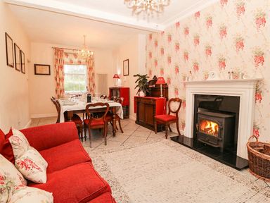 A dining room with a fireplace and a dining table at Craig Y Glyn