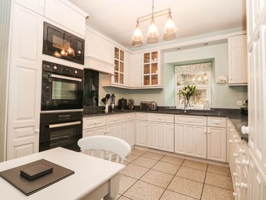 A kitchen with appliances and cabinets at Craig Y Glyn