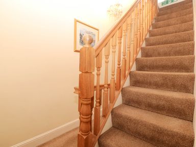 A staircase with a handrail and painting at Craig Y Glyn 