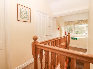 A hallway with a staircase and picture frame at Craig Y Glyn