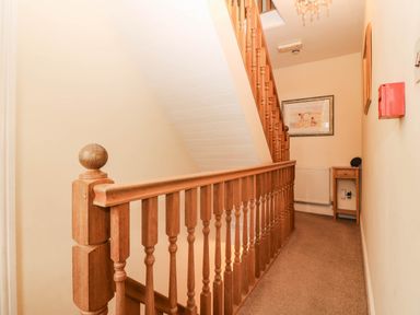 A staircase and handrail in a hallway at Craig Y Glyn