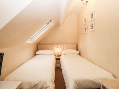 A bedroom with two single beds and a nightstand at Craig Y Glyn
