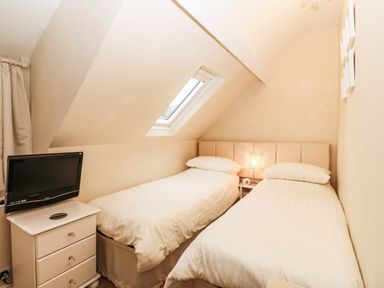 A bedroom with two beds and a television at Craig Y Glyn 