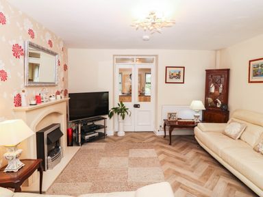 A living room with a television and sofa at Craig Y Glyn Cottage Pwllheli