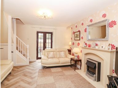 A living room with a sofa and fireplace at Craig Y Glyn Cottage in Pwllheli