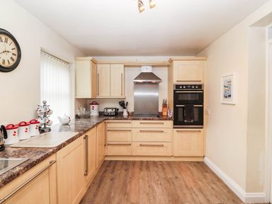 A kitchen with cabinets and appliances at Craig Y Glyn Cottage Pwllheli