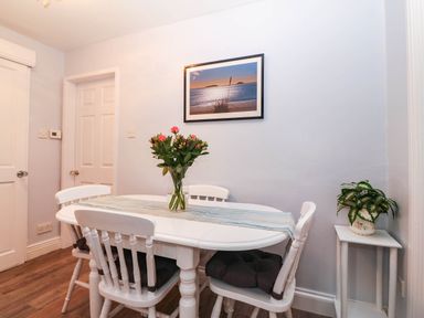 A dining room with a table and chairs at Craig Y Glyn Cottage in Pwllheli
