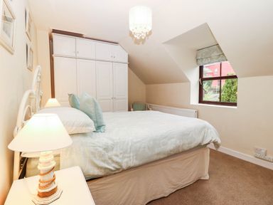 A bedroom with a bed and wardrobe at Craig Y Glyn Cottage Pwllheli