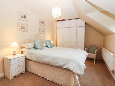 A bedroom with a bed and nightstand at Craig Y Glyn Cottage in Pwllheli
