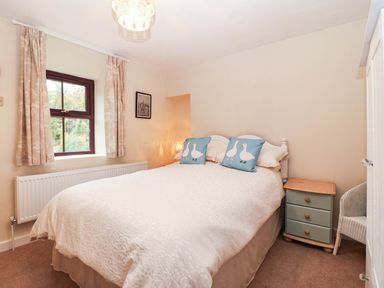 A bedroom with a bed and a window at Craig Y Glyn Cottage in Pwllheli