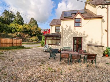 An outdoor area with a table and chairs at Craig Y Glyn Cottage in Pwllheli