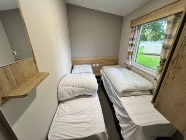 A bedroom with two beds and a window at Hafan y Mor - 159 Snowdonia Pwllheli