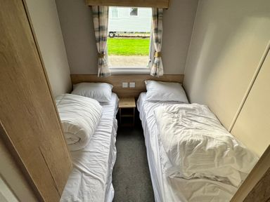 A bedroom with two beds and a window at Hafan y Mor - 159 Snowdonia Pwllheli