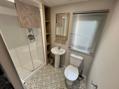 A bathroom with a shower, toilet, and sink at Hafan y Mor - 159 Snowdonia in Pwllheli